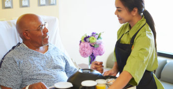 elderly man and caregiver serving his meal