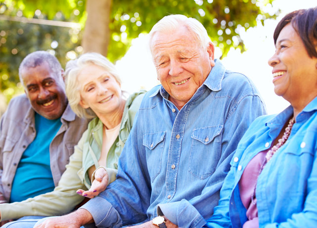 caregiver and three elderly people talking